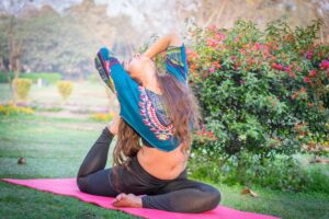 a woman stretching on a mat outside